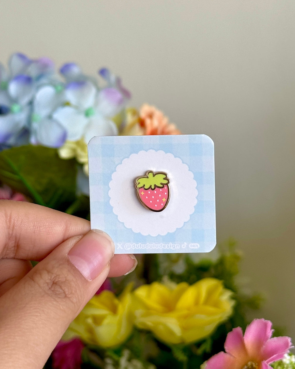 hand holding pink strawberry mini pin