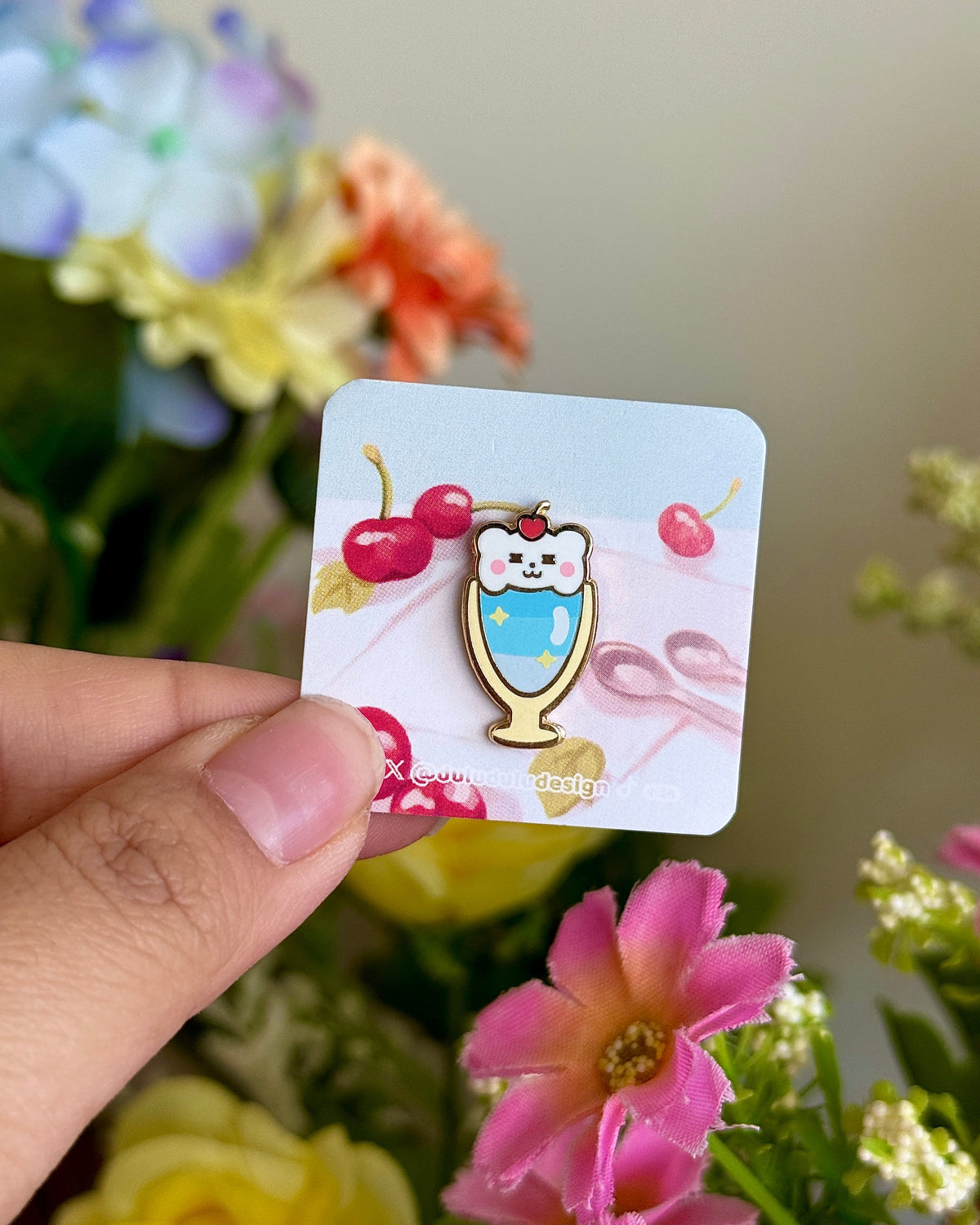 Hand holding bear parfait mini pin under natural lighting