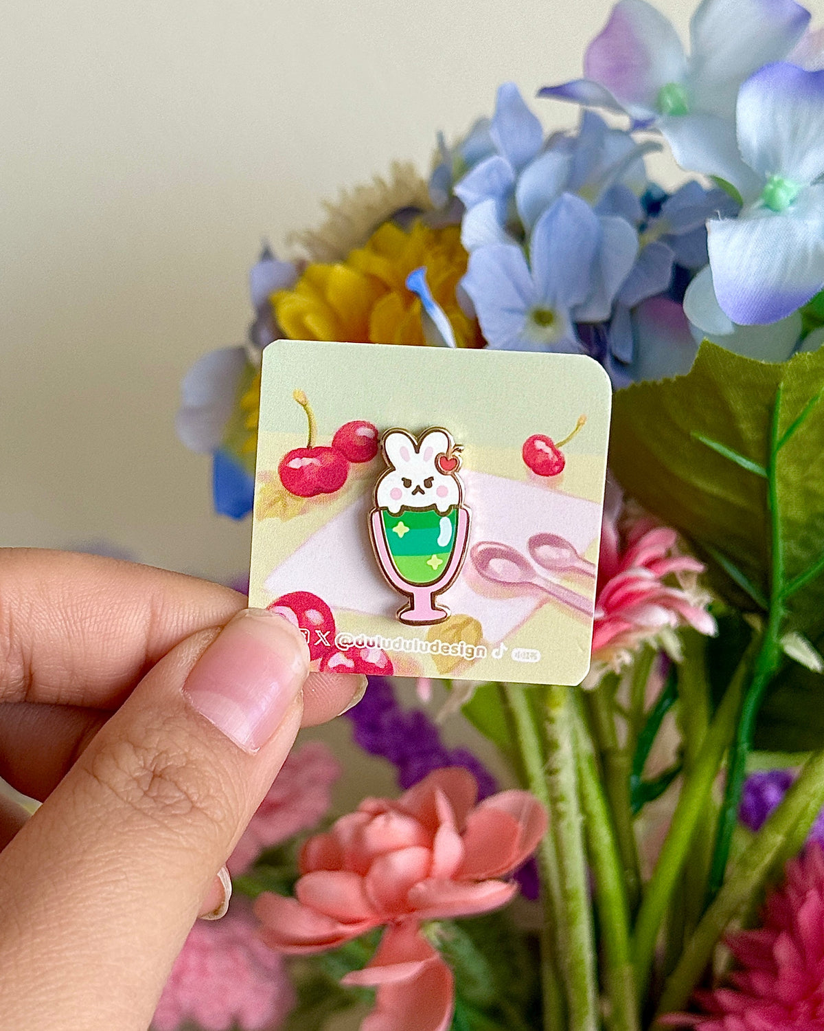 Hand holding bunny parfait mini pin under natural lighting