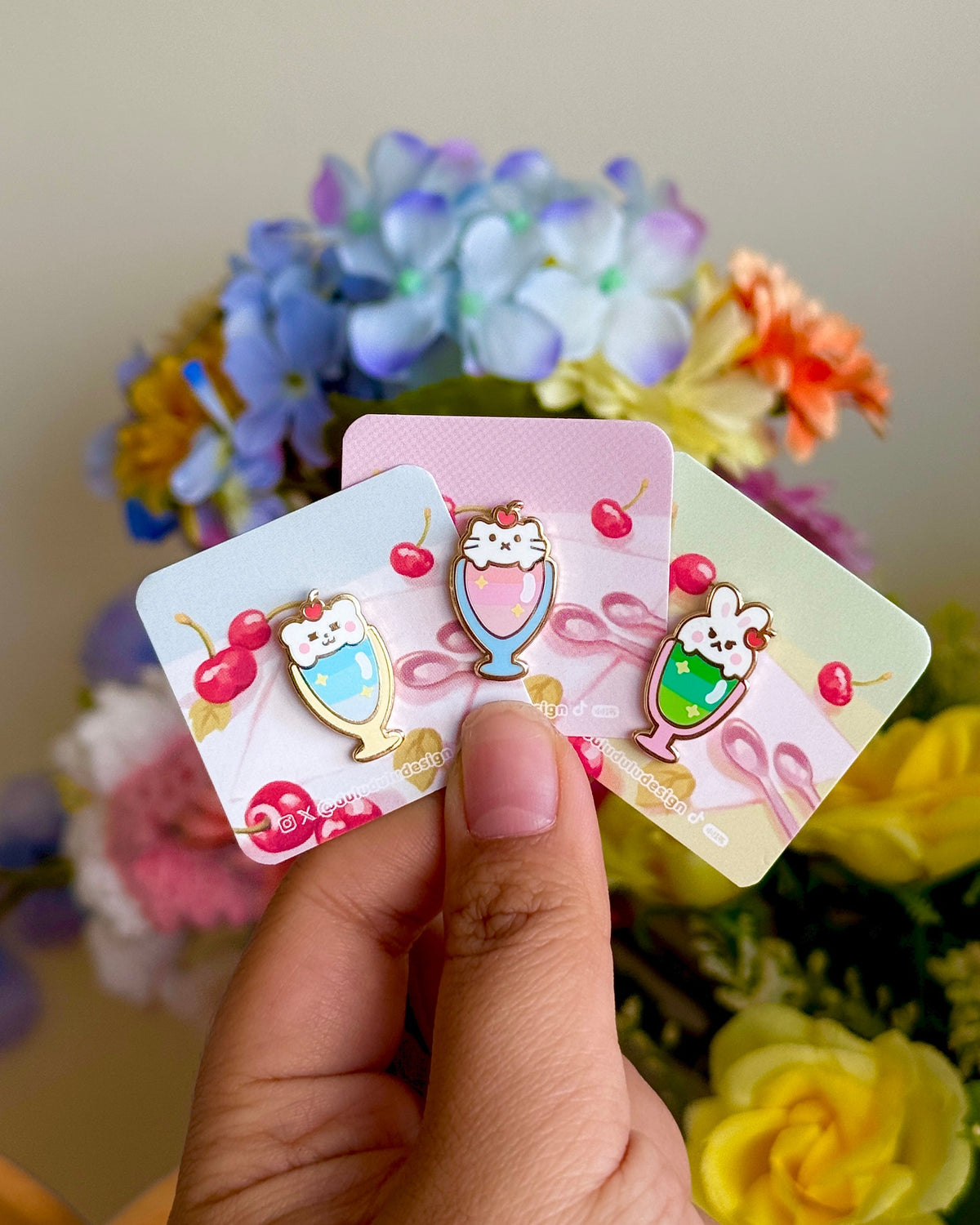 Hand holding cute mini pins in animal parfait style, under natural lighting.