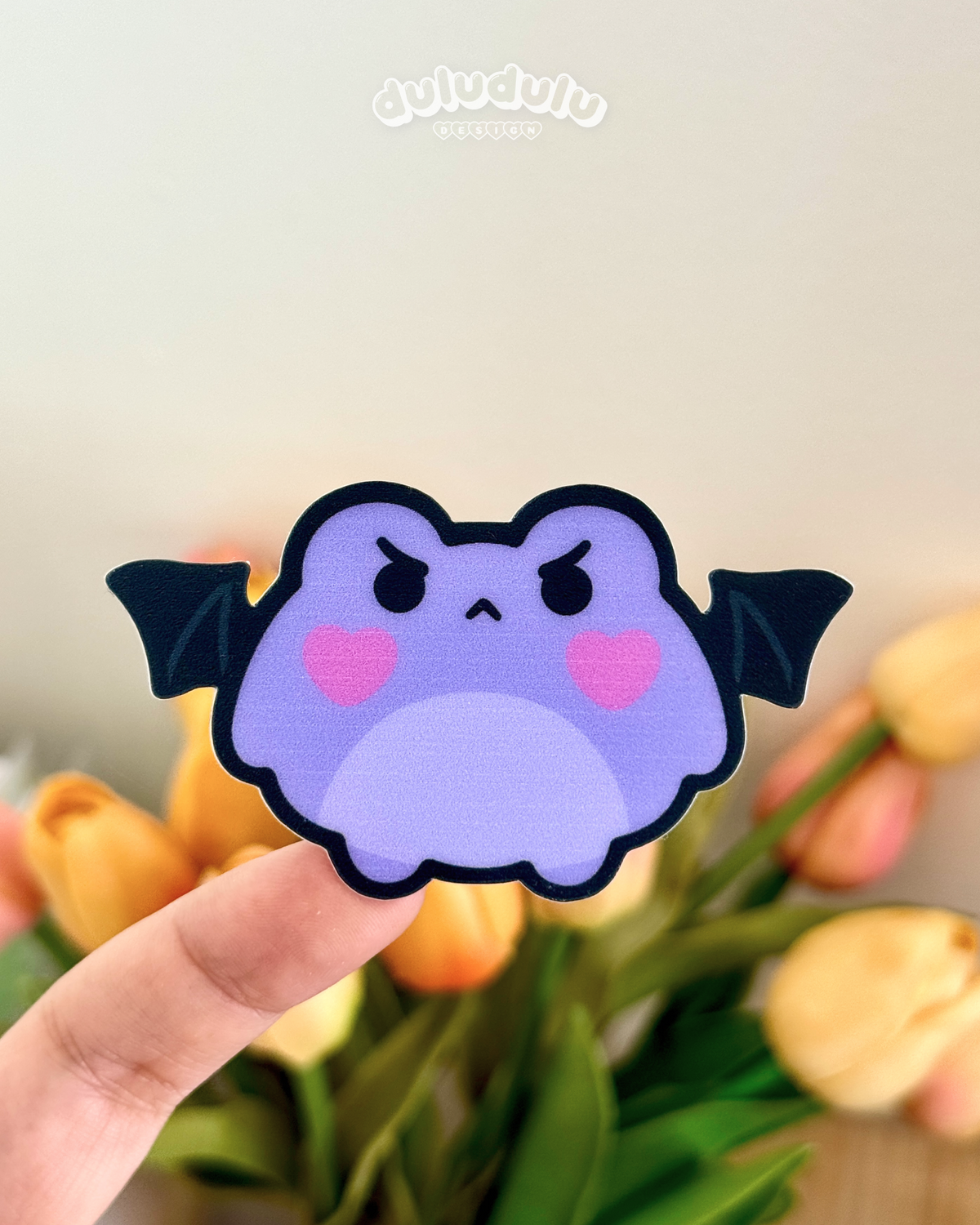 A purple frog with angry face and little bat wings