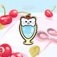 bear with a cherry in a parfait, as a mni pin in front of an illustrated background