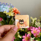 hand holding black shiba inu mini pin under natural lighting