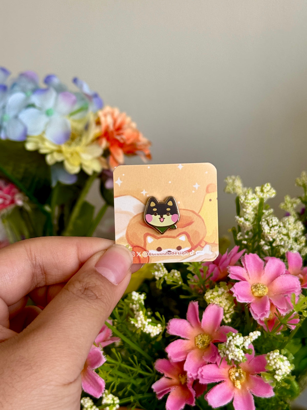hand holding black shiba inu mini pin under natural lighting