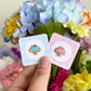 Hand holding blue and pink jello mini pins