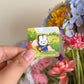 hand holding mini blue miffy pin under natural lighting
