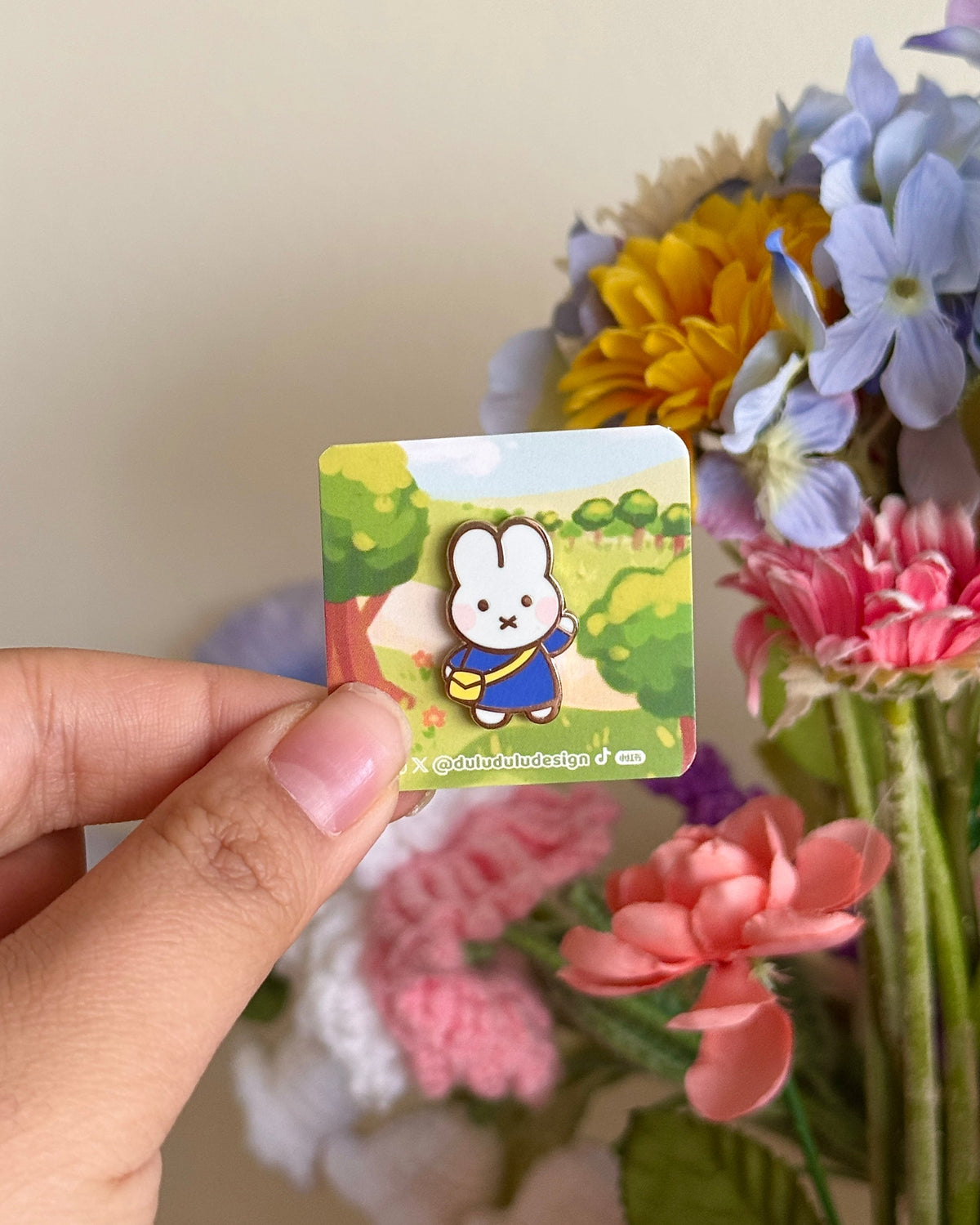 hand holding mini blue miffy pin under natural lighting