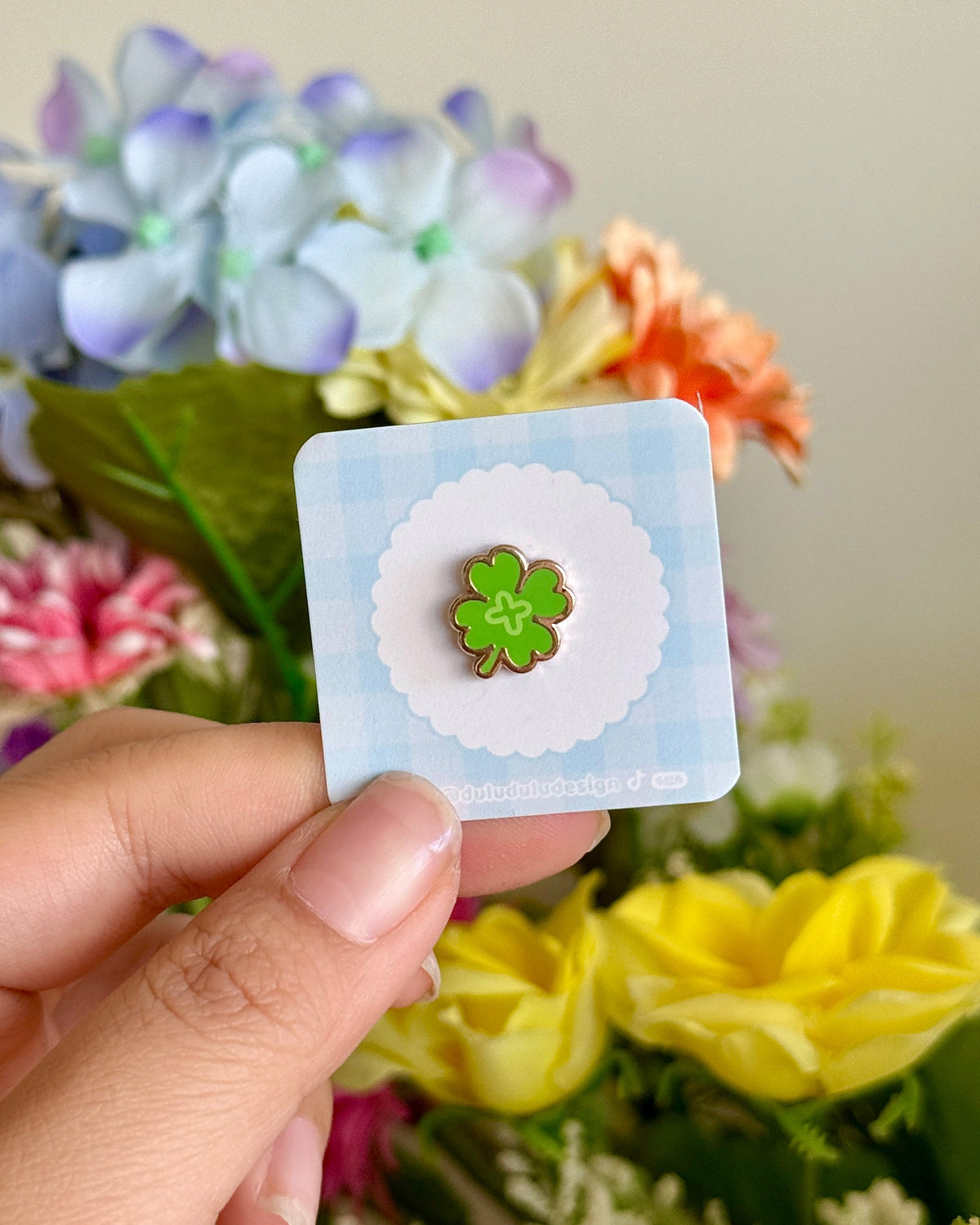 hand holding a four leaf clover mini pin