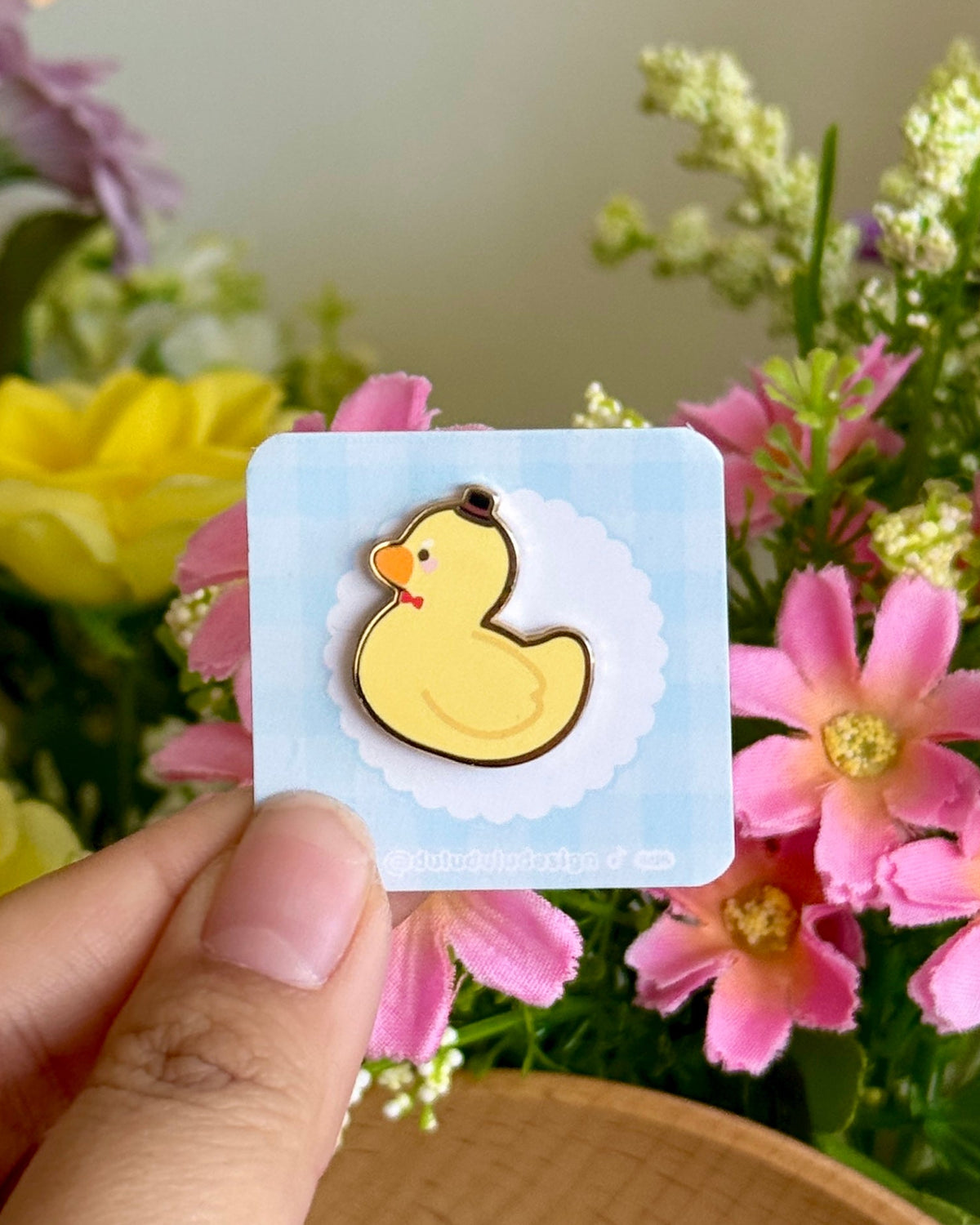 hand holding gentle duck mini pin under natural lighting