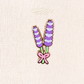 A lavender flower enamel pin displayed on a textured cream fabric background.