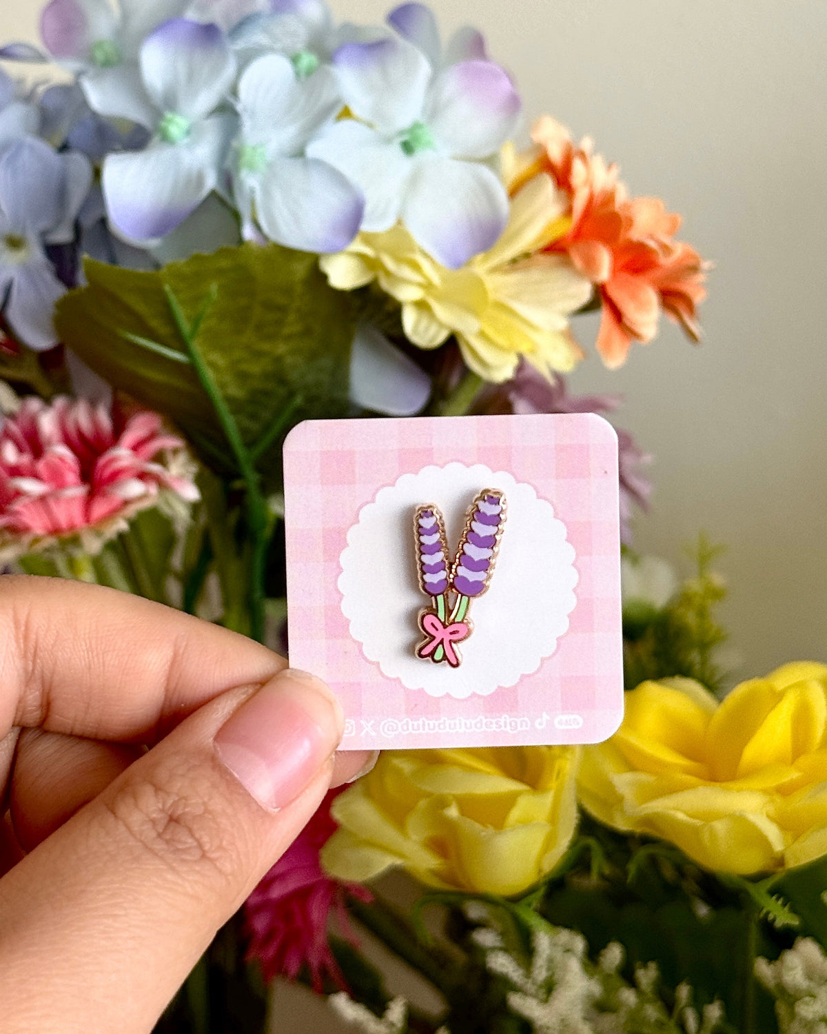 hand holding a mini lavender pin under natural sunlight