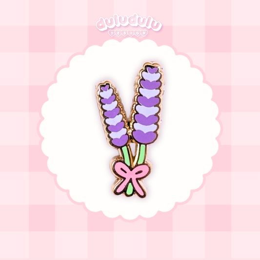 A lavender bouquet enamel pin displayed on a white scalloped circle over a pink checkered background.
