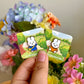 hand holding 2 miffy enamel pins under natural lighting
