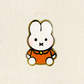 mini orange miffy pin on a plain background