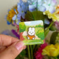 hand holding mini orange miffy pin under natural lighting
