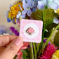 Hand holding pink jello mini pin