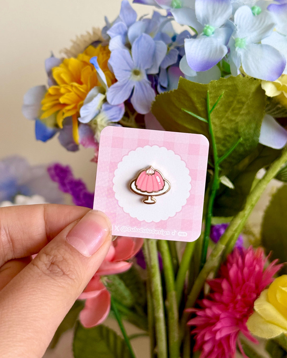 Hand holding pink jello mini pin