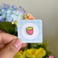 hand holding pink strawberry mini pin