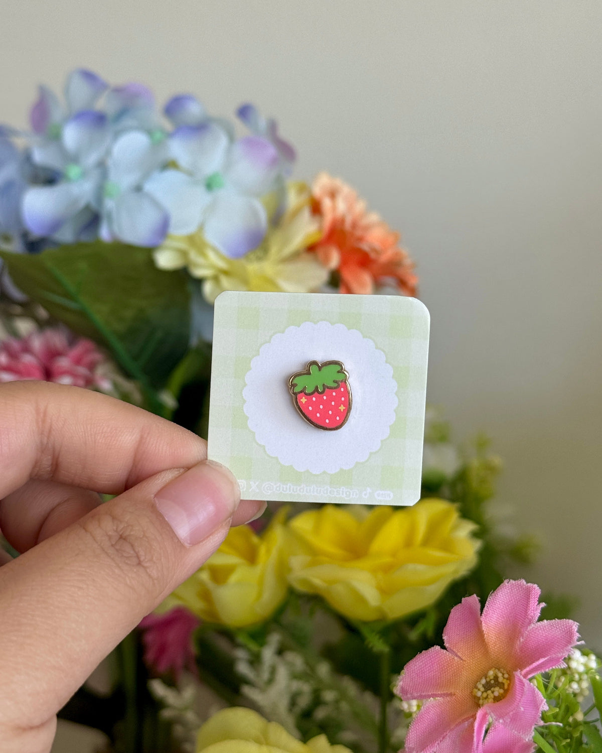 hand holding red strawberry mini pin