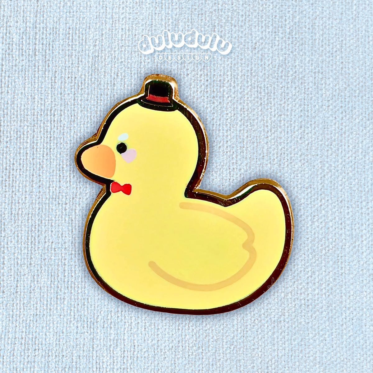 A cute rubber duck enamel pin wearing a bow tie and top hat