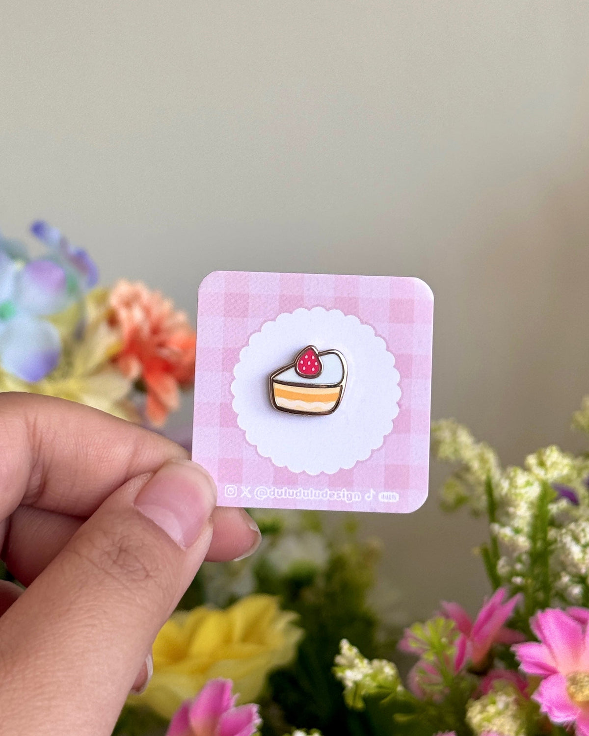 hand holding strawberry shortcake mini pin under sunlight