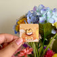 hand holding yellow shiba inu mini pin under natural lighting