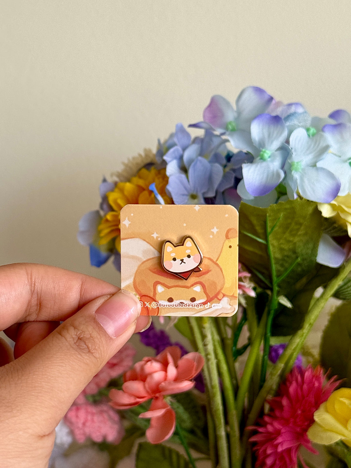 hand holding yellow shiba inu mini pin under natural lighting